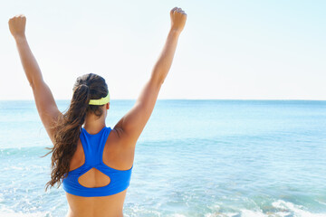 Woman, back and winner, arms up and ocean with success and runner at the beach, fitness and...