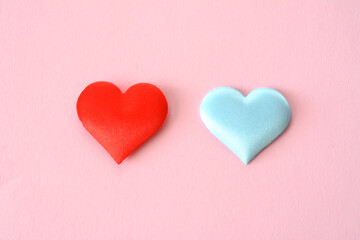 red and blue hearts isolated on the pink background close up