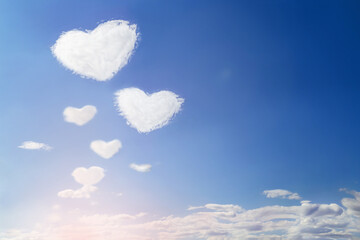 Fluffy clouds forming a heart shape on blue sky, soft focus. Valentine day, love, romantic, Mother...