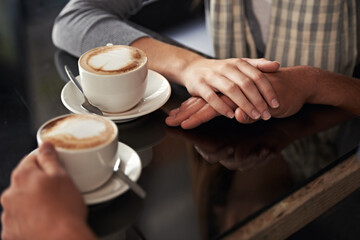 Coffee cup, cafe and relax couple holding hands for support, empathy and care on morning date with...
