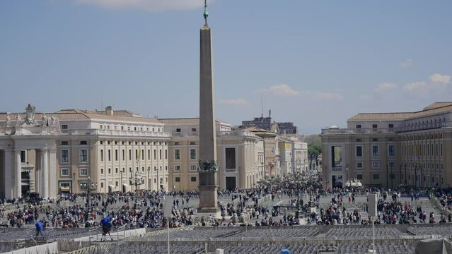 Crowd of tourist people at St. Peter square in Vatican during Eastern holidays with central position of Egyptian obelisk