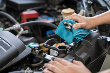 A woman is opening radiator cap