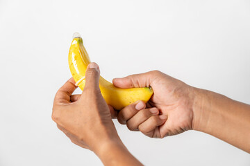  hand demonstrating the use of a condom with a banana