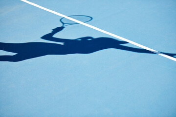 Shadow, tennis and player on outdoor blue court for serving, match or game start in training or competition. Person, athlete or silhouette of ball serve, practice or sports fitness on mockup space © Marine Gastineau/peopleimages.com
