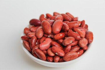 Red kidney bean, in a bowl, isolated on white background