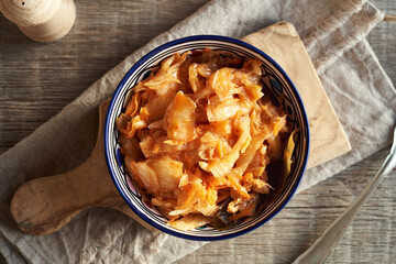 Fermented kimchi salad in a white and blue bowl, top view - obrazy, fototapety, plakaty