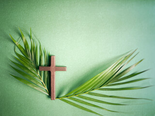 Lent Season,Holy Week and Palm Sunday Concepts - wooden cross with palm leaf in green vintage...
