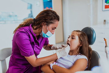 A cheerful girl undergoes a dental examination in a modern pediatric dentistry clinic