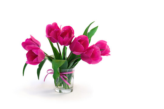 Bouquet pink tulips flowers in glass white vase with space for text on table on a white background with space for text
