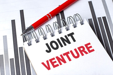JOINT VENTURE text written on notebook with pen on chart