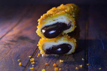 Roti goreng or fried bread with chocolate filling. sliced, on a wooden table.