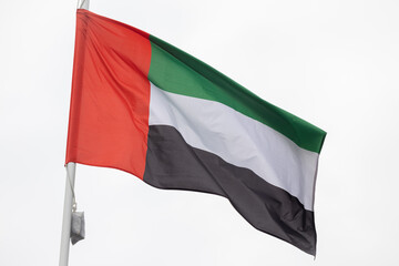 Flag of the United Arab Emirates. A large National UAE flag flutters in the wind. Close-up. Great for news. United Arab Emirates flag on white background