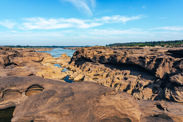 Fototapeta premium Grand Canyon in Thailand, Nature of rock canyon in Mekong River, Dry rock reef in the Mekong River with mountain hills. View of Sam Phan Bok is called Valley of Thailand. Nature landscape background.