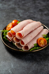 Delicious ham slices in a plate, over dark background © Inga