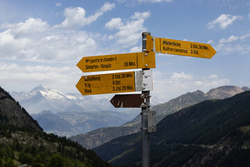 Walking trail directional signs at the famous Simplon Pass in Switzerland, with distance...