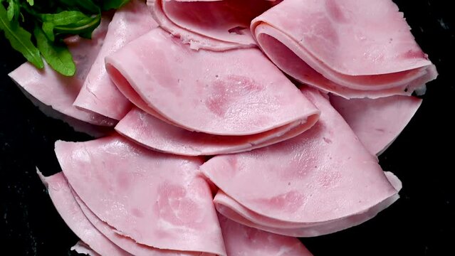 Delicious pork ham slices over dark background, top view