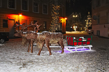 Reindeer with a sleigh against the background of the market square in Lubliniec. Christmas decoration. Christmas 2023.