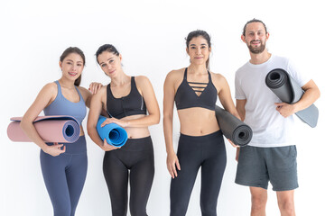 Group of happy sporty women and guy wearing body stylish sportswear holding personal carpets leaned on a white background. waiting for yoga class or body weight class. healthy lifestyle and wellness