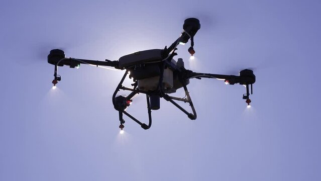 Detalle de un drone de agricultura fumigando un campo de cultivo.