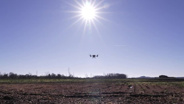 Detalle de un drone de agricultura fumigando un campo de cultivo.