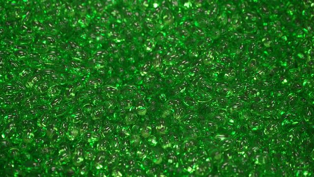 Multitud de p&iacute;ldoras verdes sobre una cubeta.