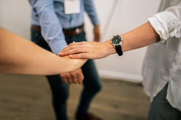 Close up of hands of young people friends holding together, unity teamwork support concept