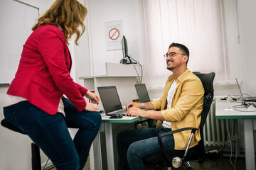 Teacher teaching young student a programming  in the classroom.