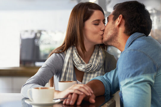 Love, Kiss And Couple In Coffee Shop, Cafe And Bonding Together On Valentines Day Date. Romance, Man And Woman In Restaurant With Latte Drink, Connection And Care In Healthy Relationship Commitment