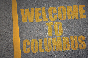 asphalt road with text welcome to columbus near yellow line.