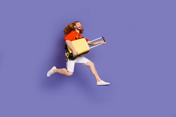 Full size photo of nice man wear print shirt jumping with suitcase hurry run to plane look empty space isolated on purple color background