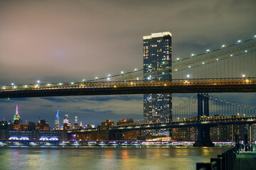 Brooklyn Bridge and Manhattan Bridge at night in winter, suspension bridges that crosses East River...