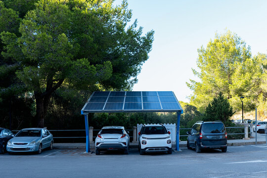 A parking area with a single solar panel structure providing shade and charging for electric vehicles