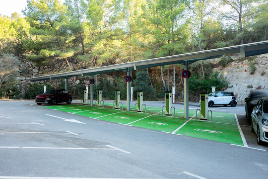 A spacious parking lot equipped with multiple solar panel canopies providing power to a row of electric vehicle charging stations