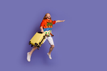 Full size photo of satisfied man wear print shirt white shorts jumping with suitcase look empty space isolated on purple color background
