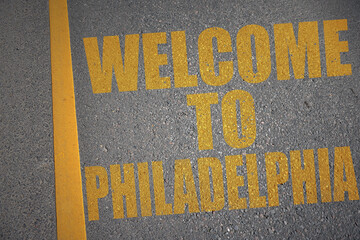 asphalt road with text welcome to Philadelphia near yellow line.