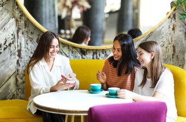 Happy multiethnic friends meeting in cafeteria