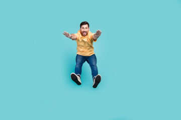 Obraz premium Full body photo of young guy purposeful muscular sportsman in casual clothes jumping doing workout isolated on cyan color background