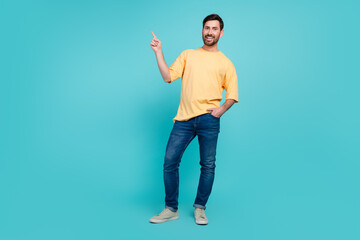 Fototapeta na wymiar Full body size photo of optimistic young brunet hair guy in yellow t shirt introduce his novelty project isolated on cyan color background