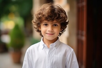 Portrait of a cute little boy with curly hair looking at camera