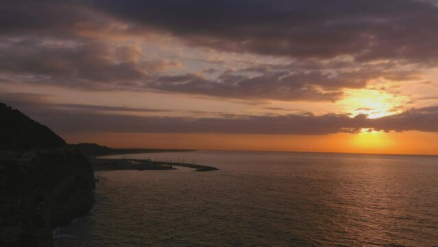Road and Ginesta port in Costa del Garraf at sunrise. Ascending drone shot