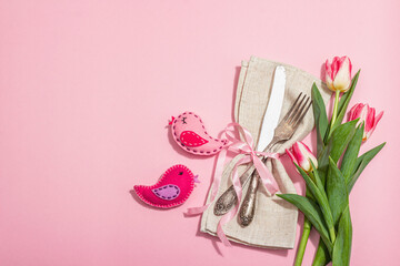 Romantic table setting with pink tulips and handmade birds. Vintage cutlery, fresh flowers, napkin