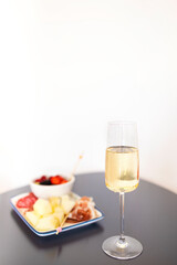 Melon, berries, grape and prosciutto with glass of champagne
