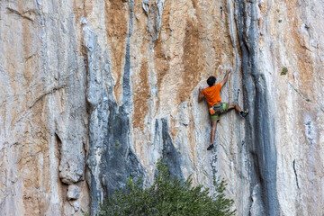 Extreme sport, man, rock climber climbs a difficult route.