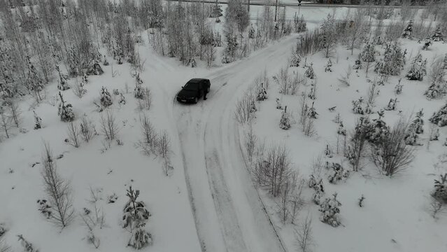 Flying drone towards e46 BMW car in snowy winter in Finland.