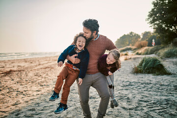Happy single father with two kids at the beach