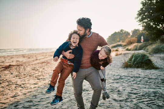 Happy single father with two kids at the beach