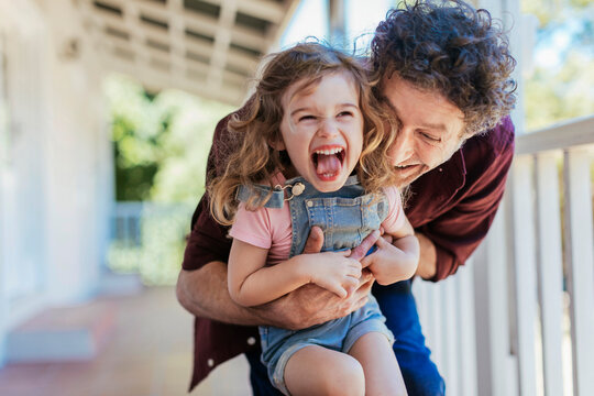 Father and daughter having fun on the porch