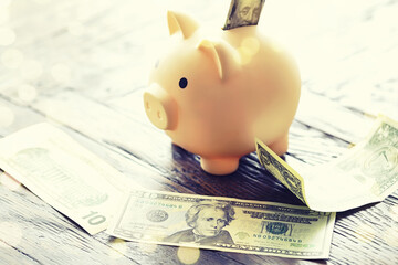 100 dollar bill and piggy bank on money background. Close up. Business, finance, investment, saving...