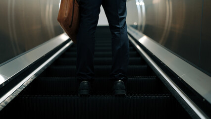 Cropped image of professional business man standing at escalators. Closeup of skilled project...