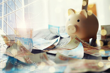 A piggy bank in the form of a pink pig stands on the wooden table with russians money, inscription...